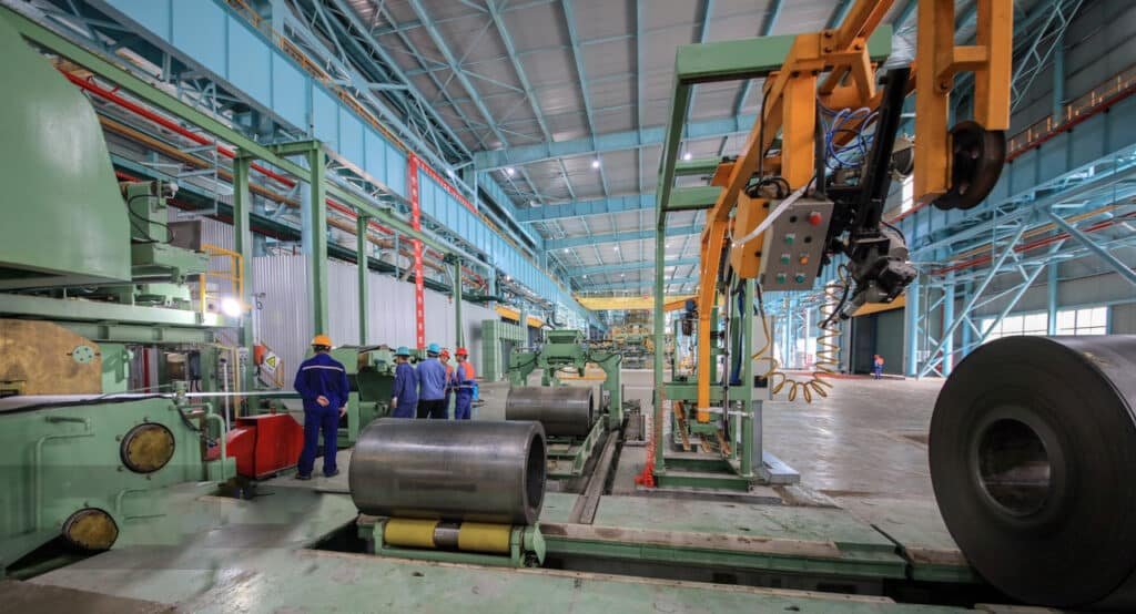 Steel pipes exiting rolling mill, hot steel production