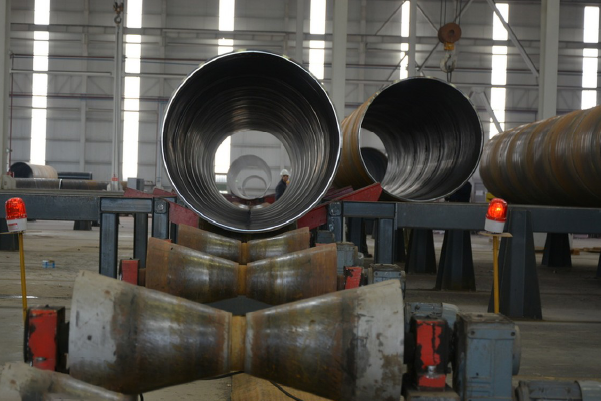 Large diameter industrial stainless steel pipes aligned for final inspection in MFY’s workshop
