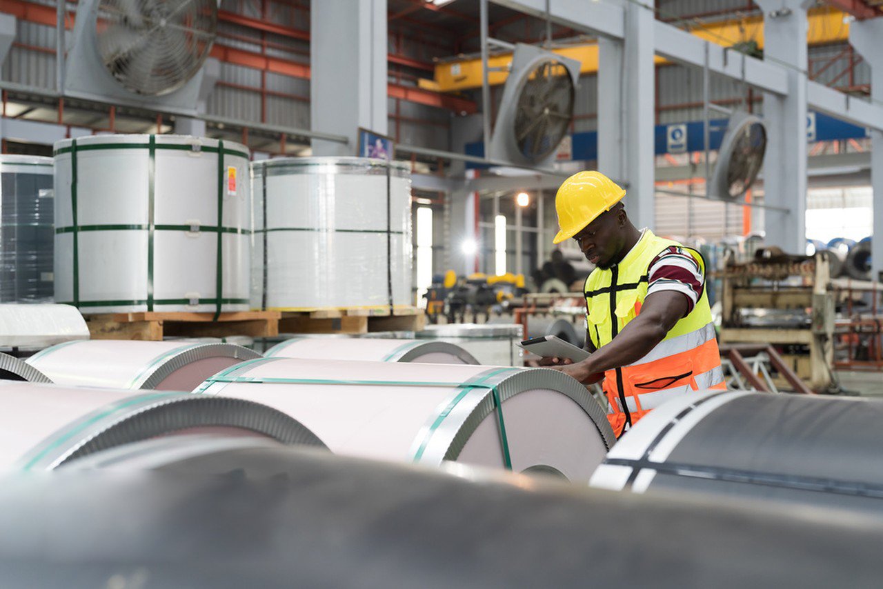 Engineer inspecting stainless steel coils in factory