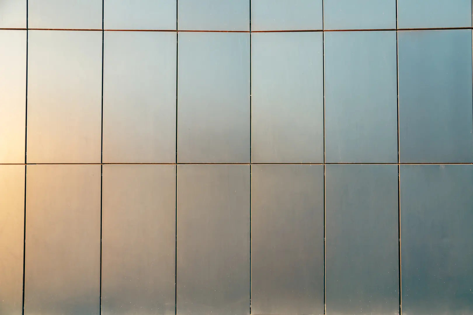 Close-up of a modern stainless steel wall with reflective panels and subtle gradient