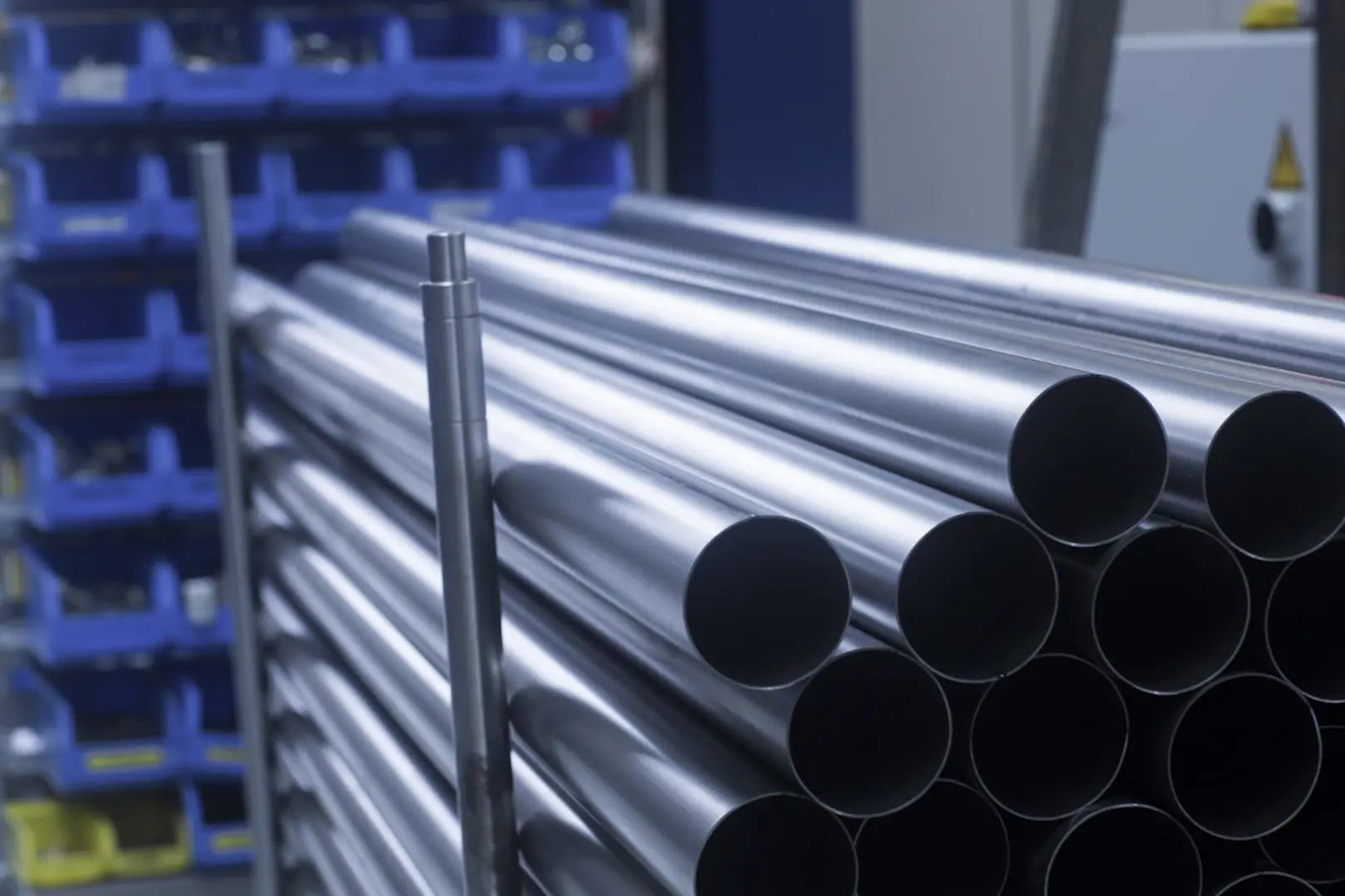 Stack of premium stainless steel tubes in a warehouse setting, highlighting MFY's industrial strength and product quality.