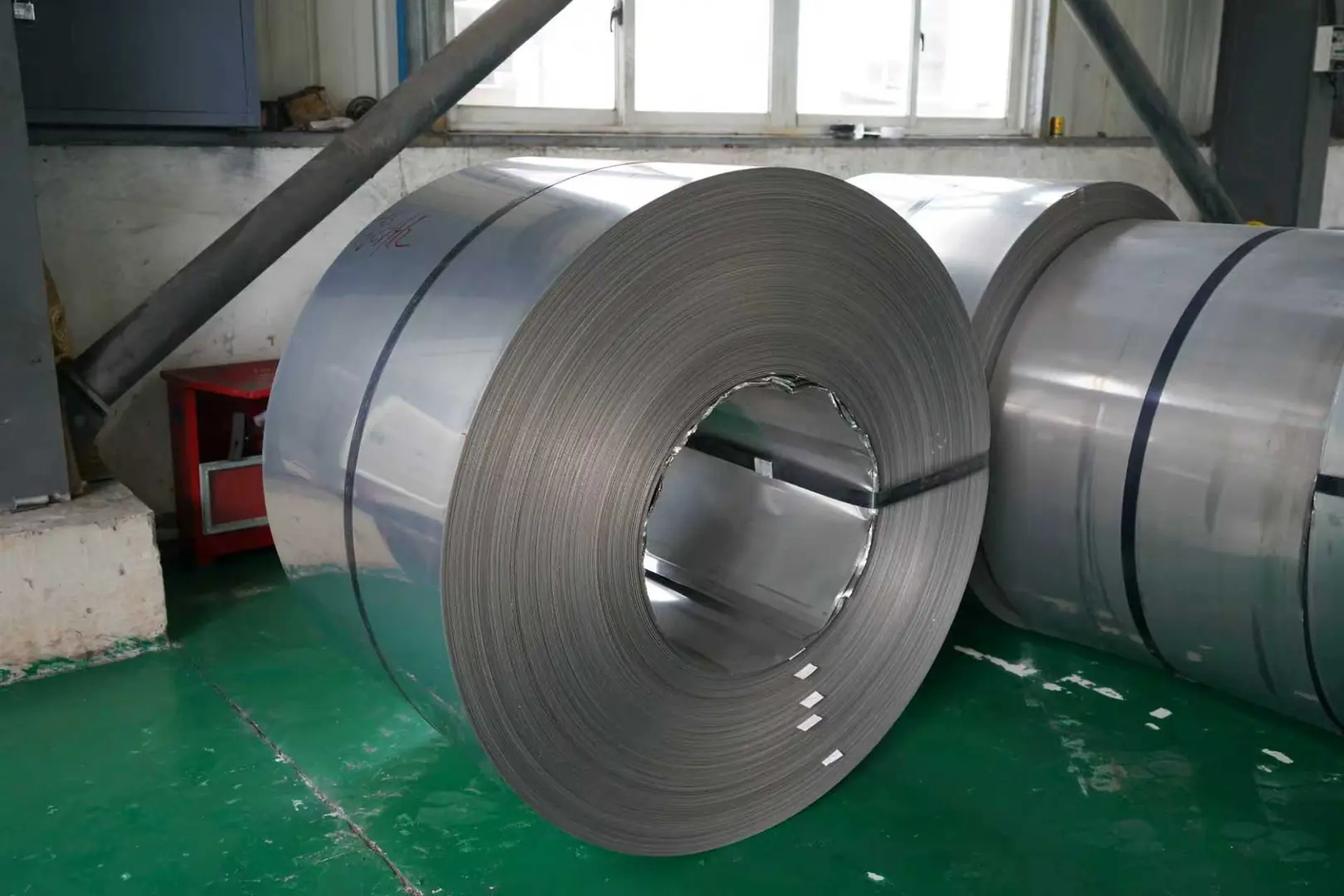 Large stainless steel coil on factory floor, showcasing MFY's manufacturing excellence