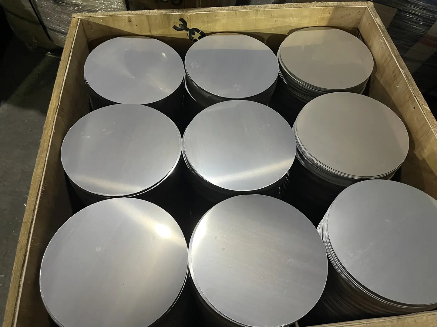 Box containing shiny, high-grade stainless steel discs for industrial use